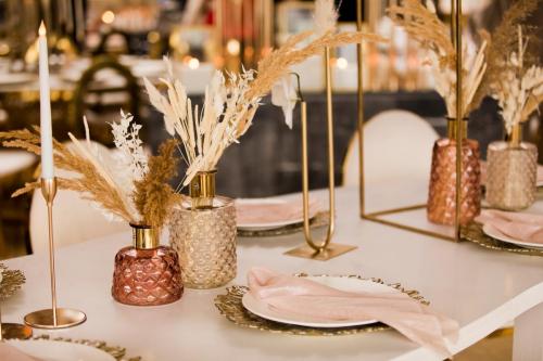Table setting at a luxury wedding and Beautiful flowers on the table. wedding decor, flowers, pink and gold decor, candles. Festive table decor.